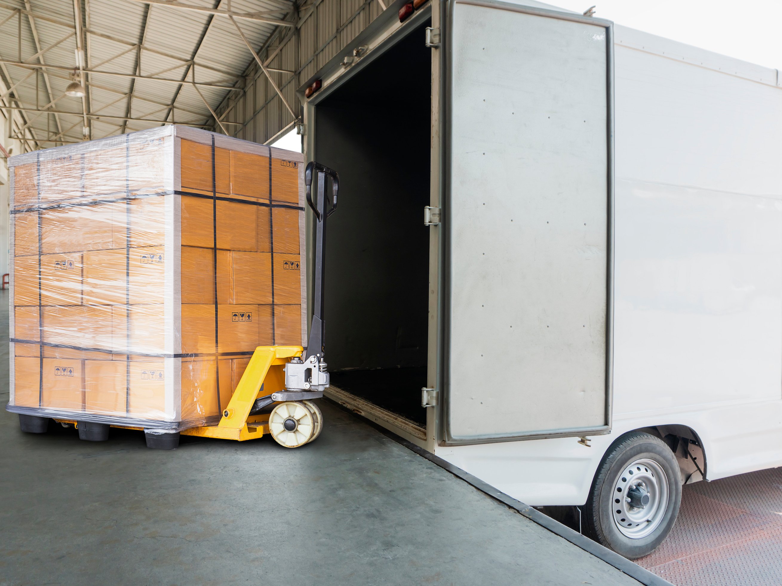 Hand pallet truck with goods pallet for load into the truck cargo